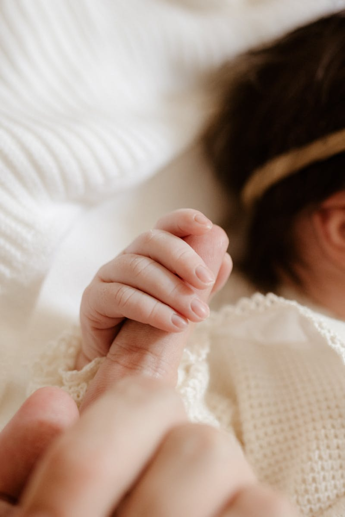 A close-up of a baby gently holding a parent's finger, symbolizing love and bonding.